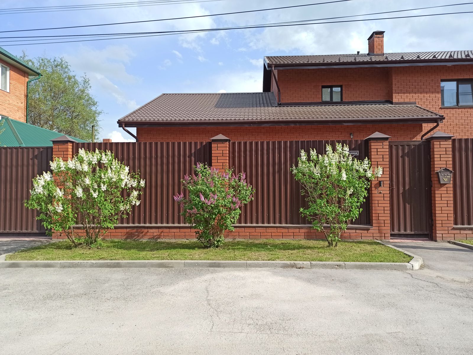 Montierter Metallzaun mit Tor an einem Wohnhaus